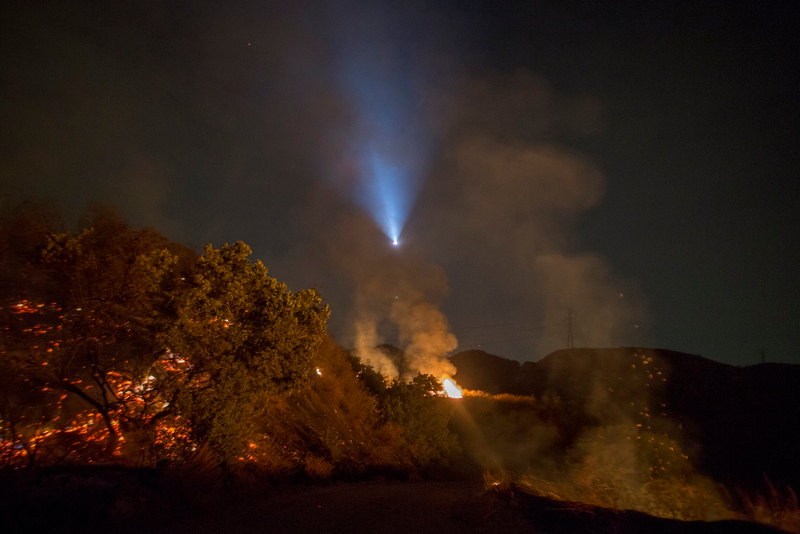 The light of a firefighting helicopter is seen during a night flight over the La Tuna Fire on September 2, 2017 near Burbank, California. (Photo by David McNew/Getty Images)